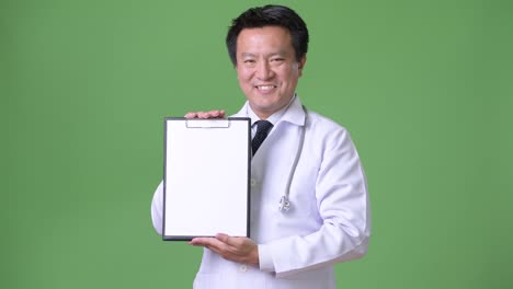 Mature-Japanese-man-doctor-against-green-background