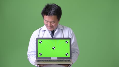 Mature-Japanese-man-doctor-against-green-background