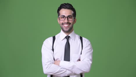 Young-handsome-bearded-Persian-businessman-against-green-background