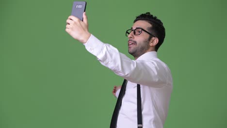 Young-handsome-bearded-Persian-businessman-against-green-background