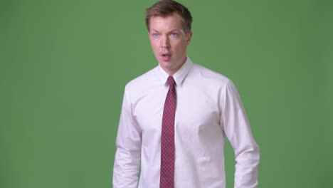 Young-handsome-Scandinavian-businessman-against-green-background