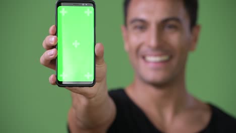 Young-handsome-Hispanic-man-against-green-background