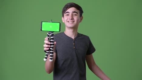 Young-handsome-Iranian-teenage-boy-against-green-background