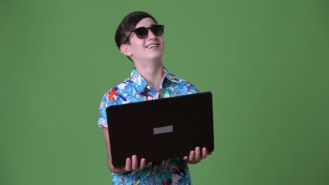 Young-handsome-Iranian-teenage-boy-ready-for-vacation-against-green-background