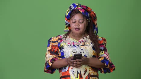 Overweight-beautiful-African-woman-wearing-traditional-clothing-against-green-background