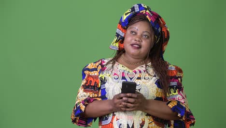 Overweight-beautiful-African-woman-wearing-traditional-clothing-against-green-background