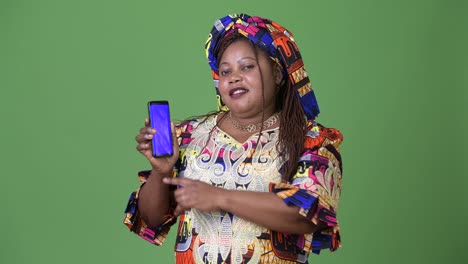 Overweight-beautiful-African-woman-wearing-traditional-clothing-against-green-background