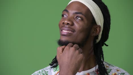 Young-handsome-African-man-with-dreadlocks-against-green-background