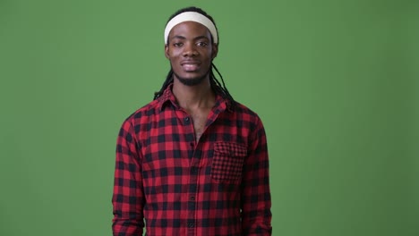 Young-handsome-African-man-with-dreadlocks-against-green-background