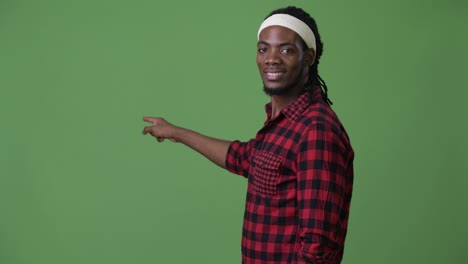 Young-handsome-African-man-with-dreadlocks-against-green-background