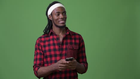 Young-handsome-African-man-with-dreadlocks-against-green-background