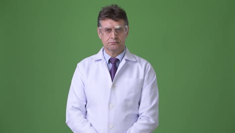 Mature-handsome-man-doctor-against-green-background