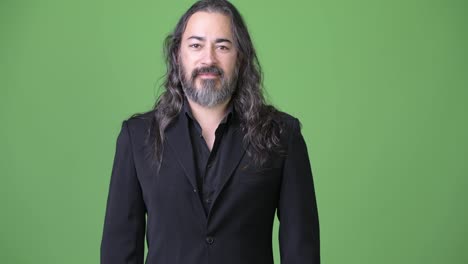 Studio-shot-of-mature-handsome-bearded-multi-ethnic-businessman-with-long-hair