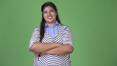 Young-overweight-beautiful-Indian-businesswoman-against-green-background