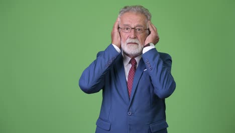 Handsome-senior-bearded-businessman-against-green-background