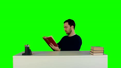 Portrait-of-a-male-student-reading-a-book-on-a-Green-Screen