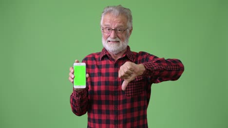 Handsome-senior-bearded-man-against-green-background