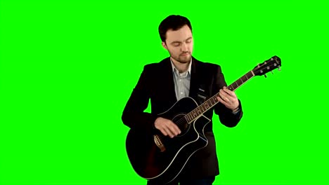 Junger-Mann-spielt-Gitarre-auf-einem-grünen-Bildschirm
