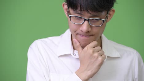 Sad-young-Asian-businessman-thinking-while-looking-down