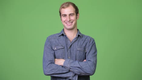 Young-happy-man-smiling-with-arms-crossed