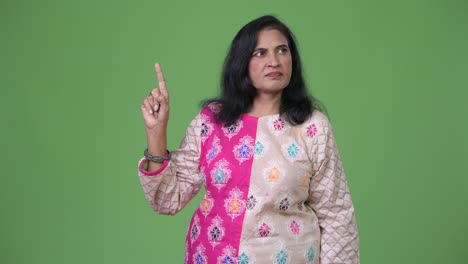 Mature-beautiful-Indian-woman-thinking-while-pointing-finger-up