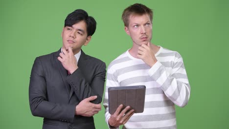 Young-handsome-Asian-businessman-and-young-Scandinavian-businessman-working-together