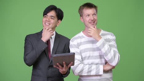 Young-handsome-Asian-businessman-and-young-Scandinavian-businessman-working-together