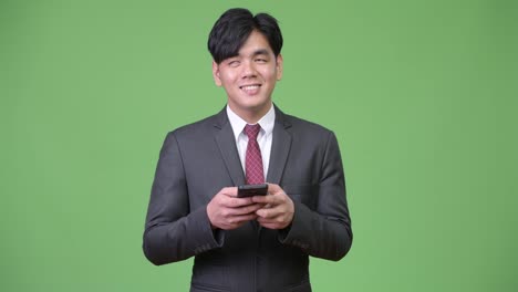 Young-handsome-Asian-businessman-using-mobile-phone