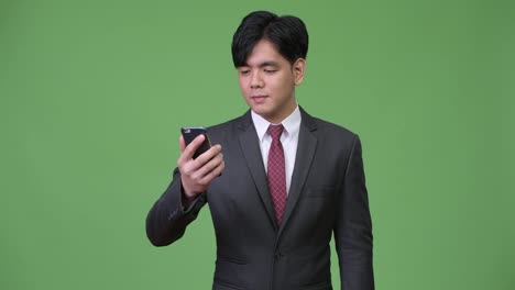 Young-handsome-Asian-businessman-using-mobile-phone