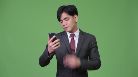 Young-handsome-Asian-businessman-using-mobile-phone