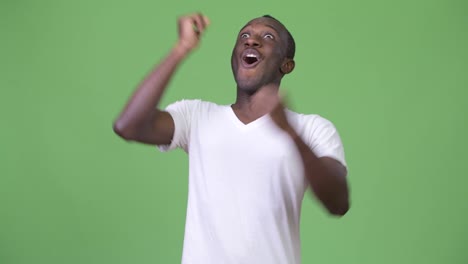 Young-happy-African-man-smiling-with-arms-raised