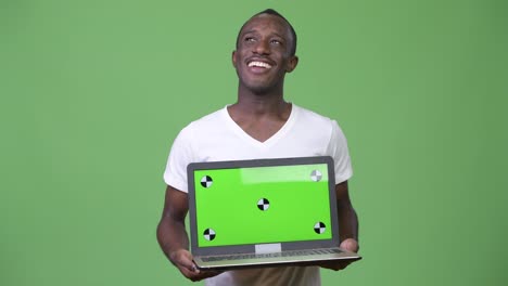 Young-African-man-thinking-while-showing-laptop