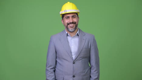 Handsome-happy-Persian-bearded-businessman-as-engineer-smiling