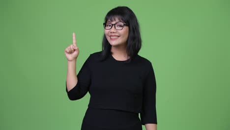 Beautiful-Asian-businesswoman-thinking-while-pointing-finger-up