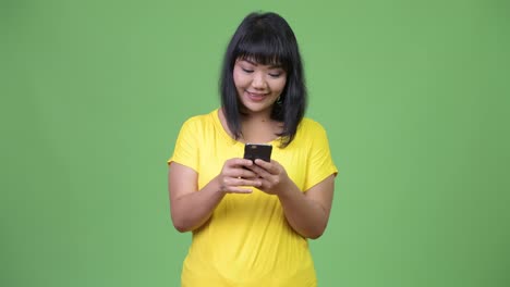 Schöne-glückliche-asiatische-Frau-mit-Telefon