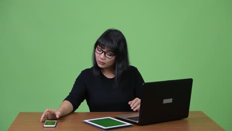 Schöne-asiatische-geschäftsfrau-Multi-tasking-und-ruft-bei-der-Arbeit