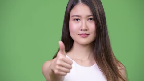 Young-beautiful-Asian-businesswoman-giving-thumbs-up