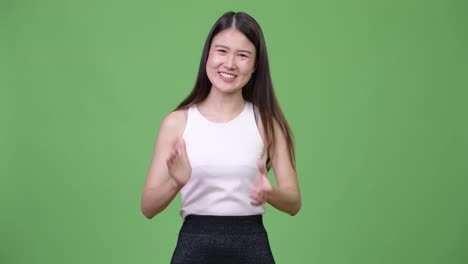 Young-beautiful-Asian-businesswoman-clapping-hands