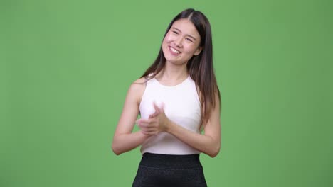 Young-beautiful-Asian-businesswoman-clapping-hands