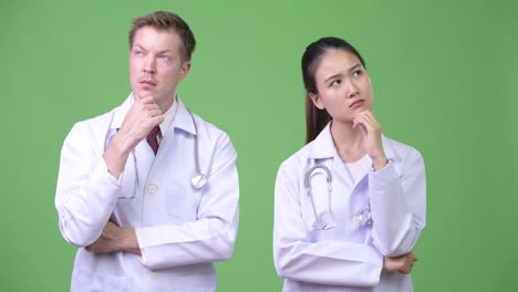 Multi-ethnic-couple-doctors-thinking-together