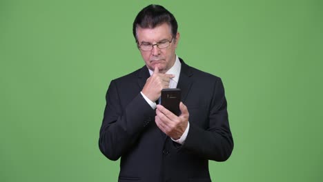 Senior-handsome-businessman-using-phone