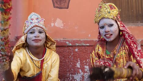 Two-females-dressed-as-Goddess-wave-broom-like-holy-want-towards-the-camera-and-look-straight-at-it,-handheld