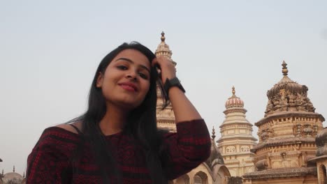 Woman-in-front-of-panoramic-attractive-ornate-temple-fort-palace-complex-from-a-vantage-point-higher-level-taking-selfie-photo-on-mobile-phone-camera-tourist--Hindu-religious-massive-love-handheld-pov