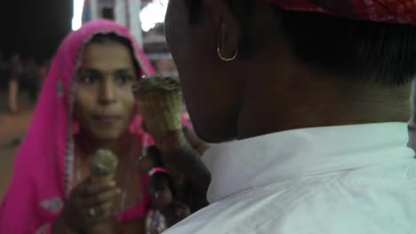 Indian-couple-eating-ice-cream-in-traditional-dresses-at-the-Pushkar-Mela,-a-carnival-of-Rajasthan,-India