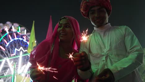 Pareja-India-en-vestido-tradicional-con-fuego-galleta-de-chispa-en-el-festival-de-Diwali-Mela-en-la-India