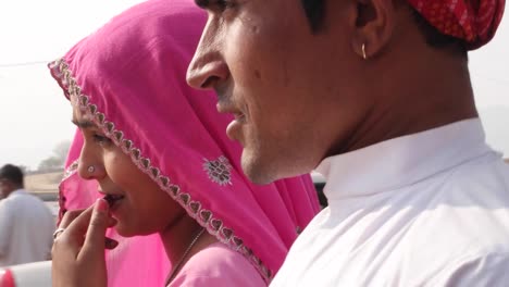 handheld-Ethnic-Indian-couple-with-traditional-clothing-walking-around-at-fairgrounds-of-Pushkar-Fair,-Rajasthan,--India