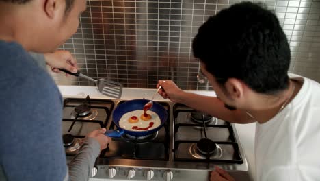 Schwule-Männer-Kochen-Eier-In-der-Küche-zu-Hause-zu-frühstücken