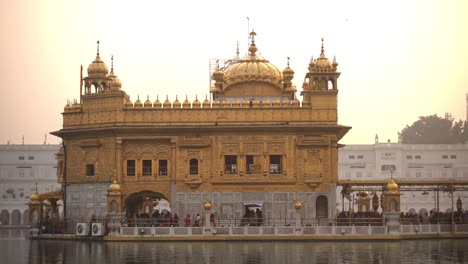 Video-of-Sikh-pilgrims-in-the-Golden-Temple-at-sunset-during-celebration-day-in-December-in-Amritsar,-Punjab,-India.-Harmandir-Sahib-is-the-holiest-pilgrim-site-for-the-Sikhs.