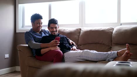 Happy-Gay-Couple-Looking-At-Pictures-On-Mobile-Phone