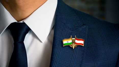 Geschäftsmann-zu-Fuß-in-Richtung-Kamera-mit-Freund-Flaggen-Pin-Indien---Österreich